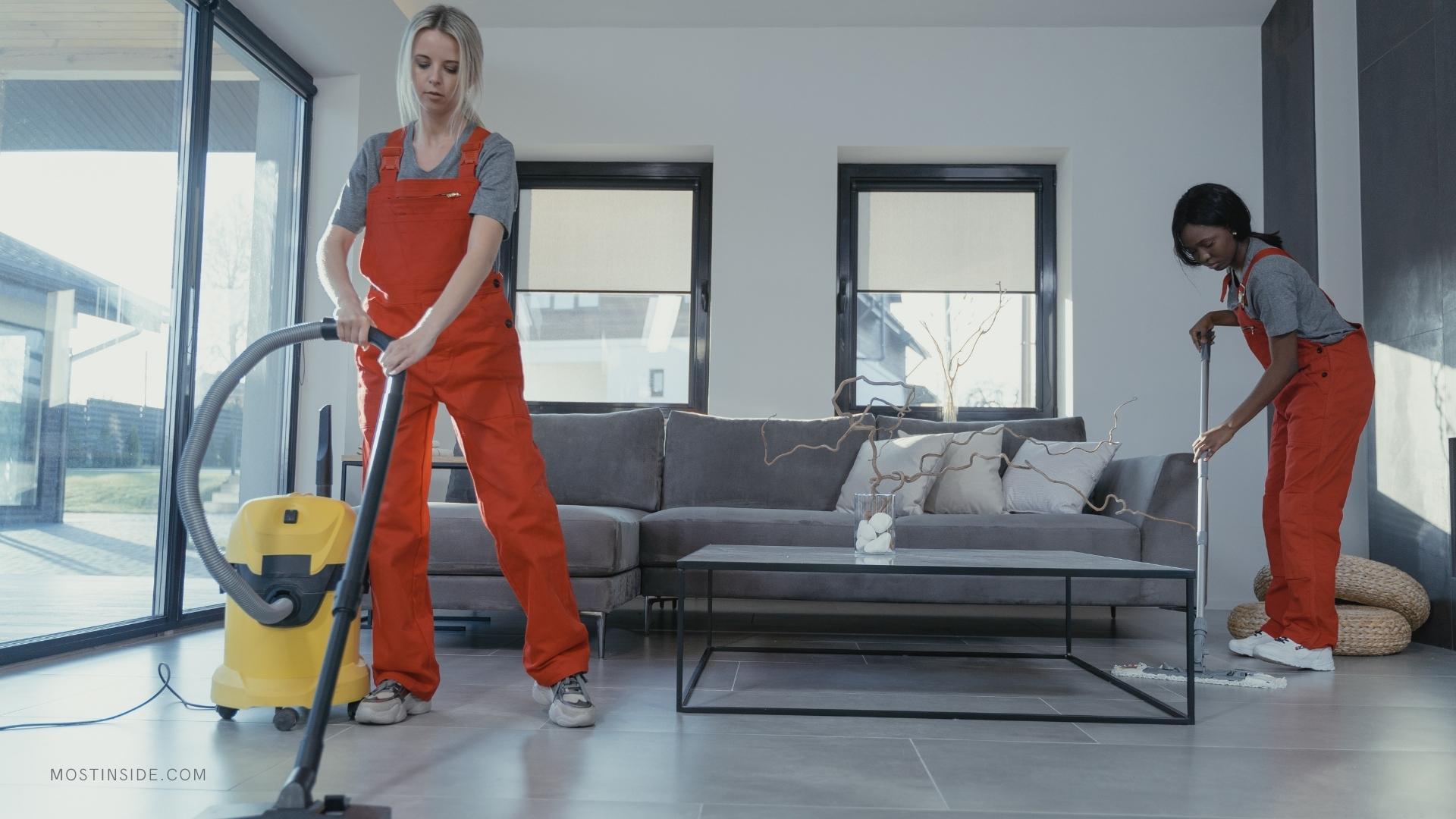 two girls are cleaning the floor