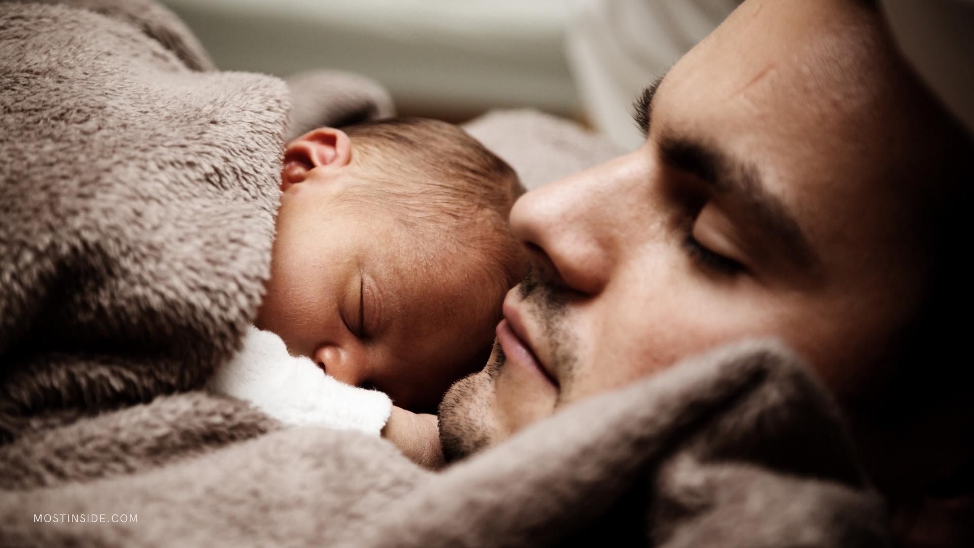 baby sleeping on father chest