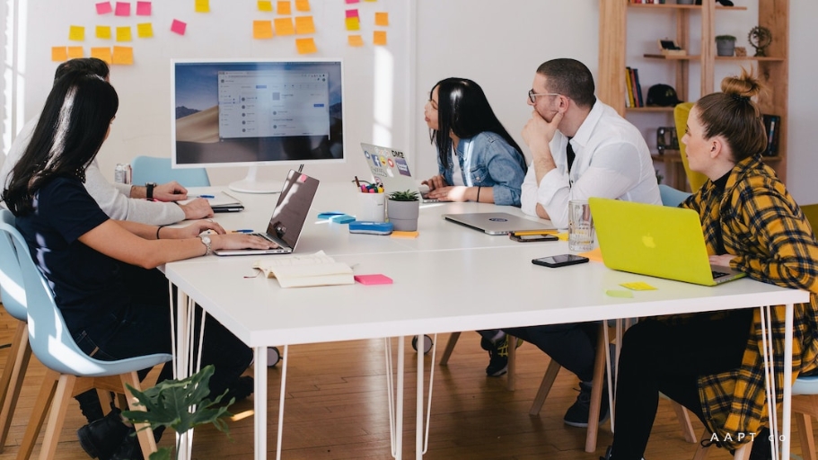 A sales team looking at a computer screen, sitting at a white table, learning about what is sales velocity.