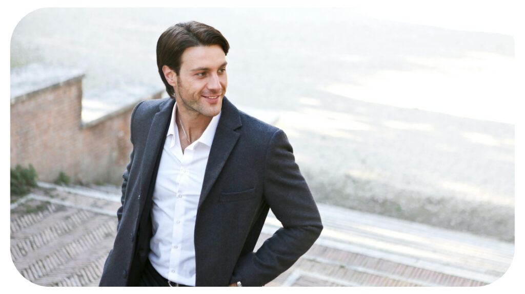 a well-dressed man walking outdoors, possibly up a set of steps.