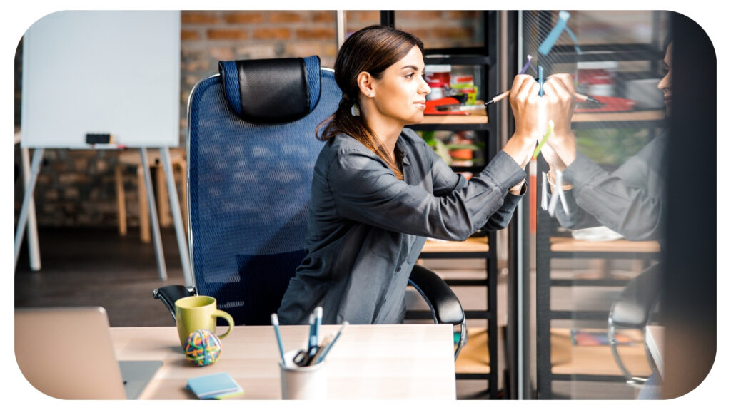 Attentive female person sticking notes on glass wall