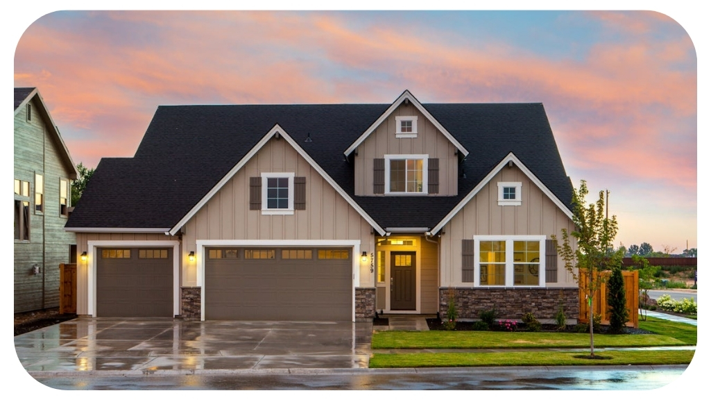Modern suburban house with a well-maintained lawn, stone accents, and double garage at sunset with a pink and blue sky in the background.