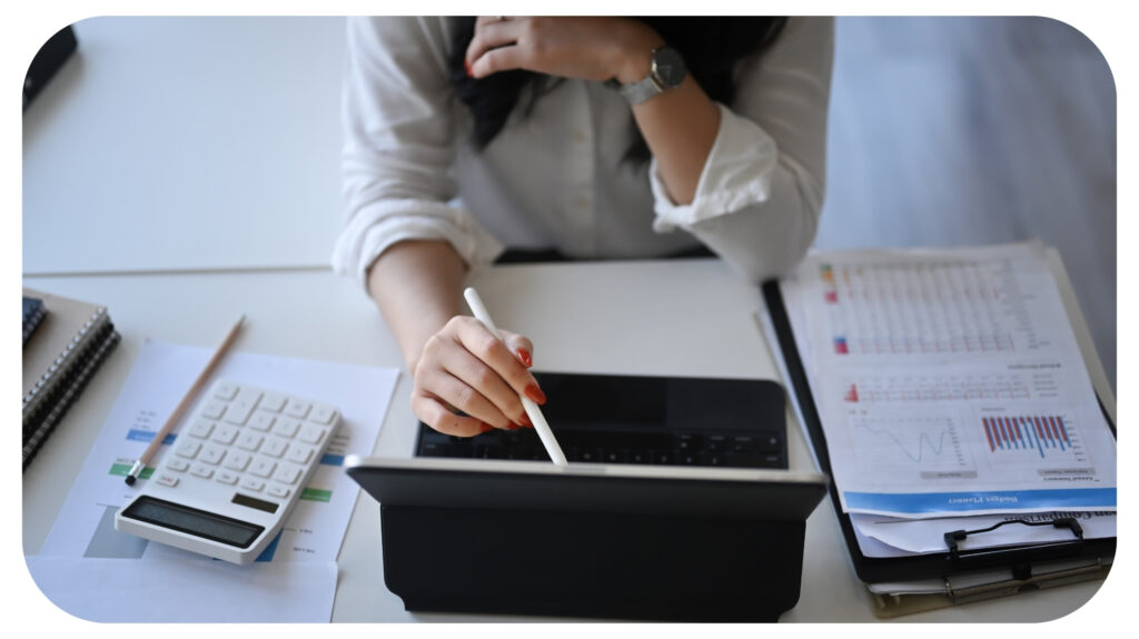Businesswoman analyzing financial data on computer tablet.