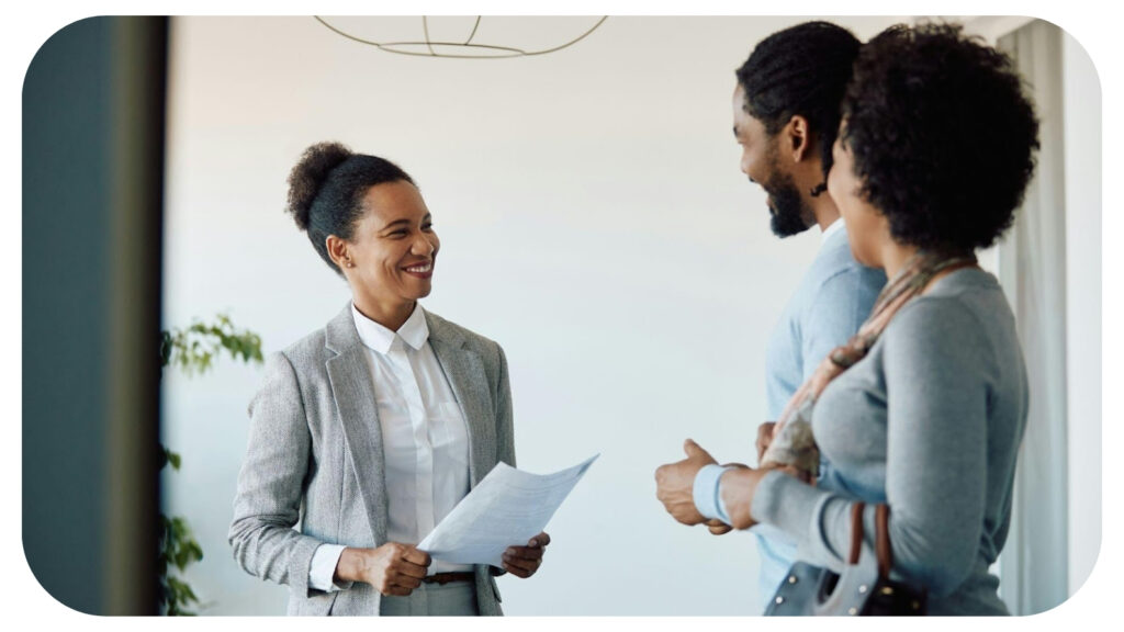 Happy black insurance agent and her clients talking while meeting in the office.