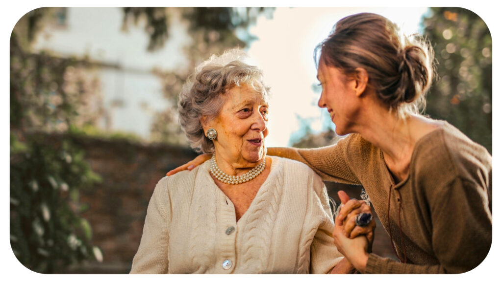 Joyful adult daughter greeting happy surprised senior mother in garden