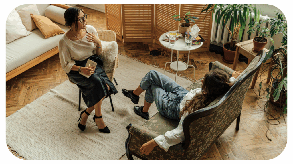 A therapist speaking with a client in a cozy, plant-filled room, representing modern mental health practice and the evolving approach clinicians need to thrive in the future.