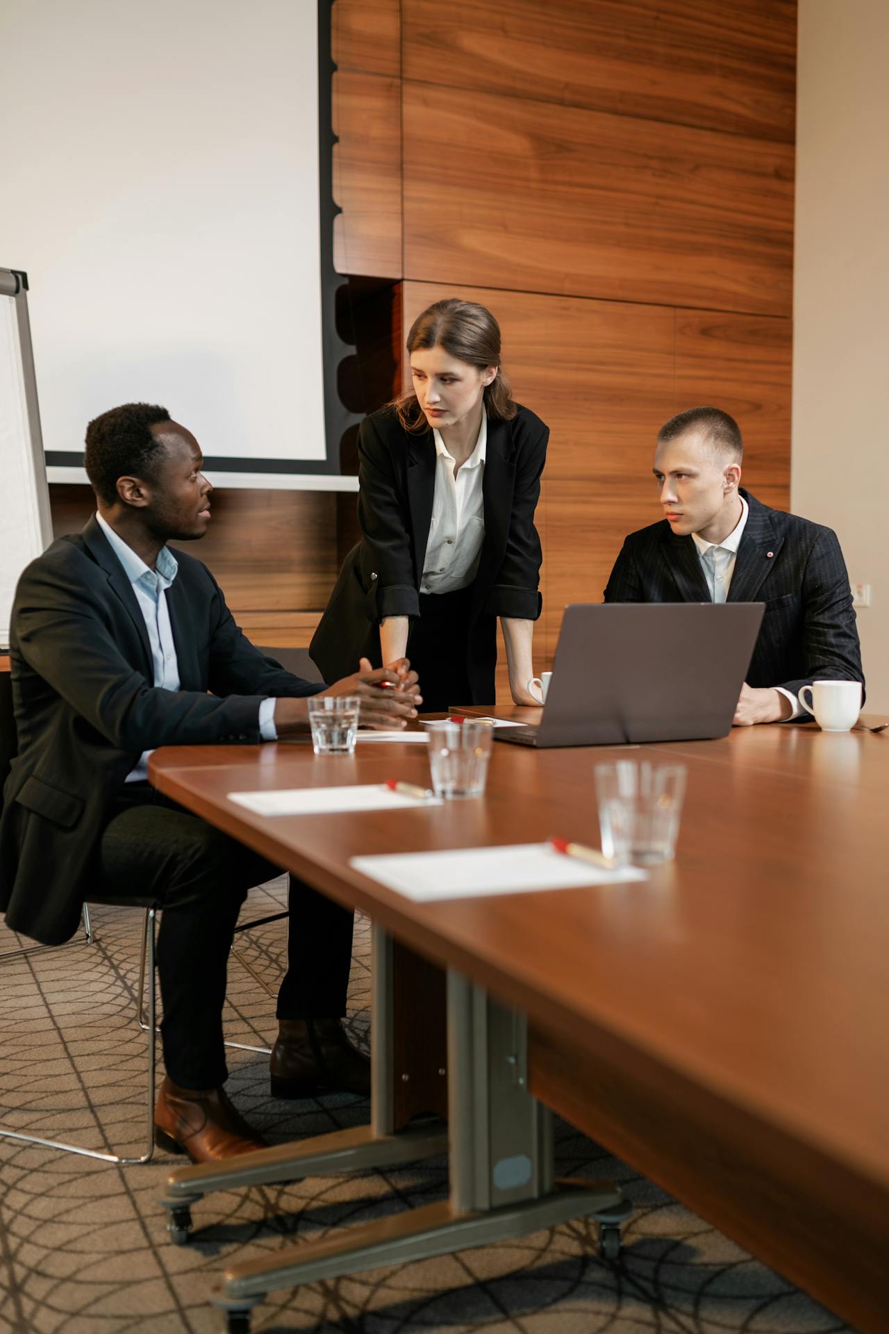 Business professionals discussing product development lifecycle strategy during a corporate meeting with laptop planning project execution teamwork and product launch management.