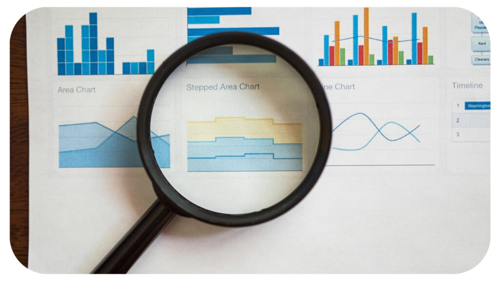 Magnifying glass placed over business analytics charts representing data analysis professional transparency client communication and responsible data collection practices.