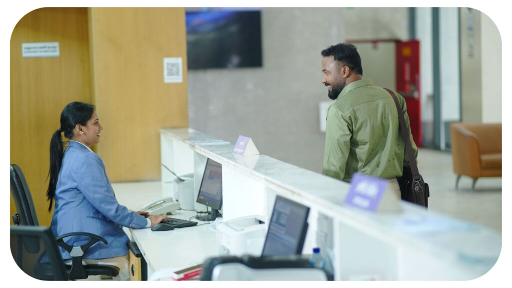 Business professional interacting with a customer service representative at a modern office reception, showcasing how IT services, digital workplace technology, managed IT support, business operations, and customer experience help organizations stay competitive in 2026.